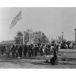 Cheyenne and Arapahoe people in circle around flagpole, at the Indian 