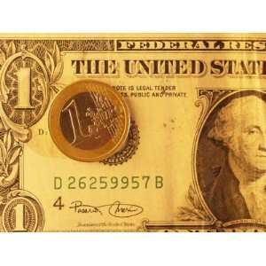  Euro Coin Lies on Top of an American Dollar Bill 