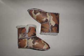   little one cozy in a pair of UGG Australia baby bootiesy camouflage
